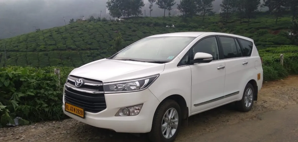 Innova Crysta parked above the Munnar tea slopes
